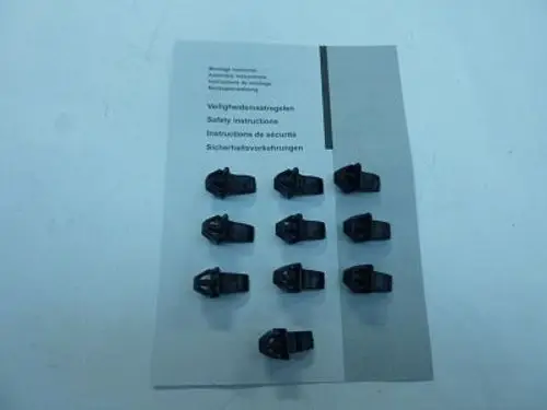 Schwarze Schnappbolzen von Remeha, angeordnet in zwei Reihen auf einer Bedienungsanleitung mit Sicherheitsinformationen in mehreren Sprachen.